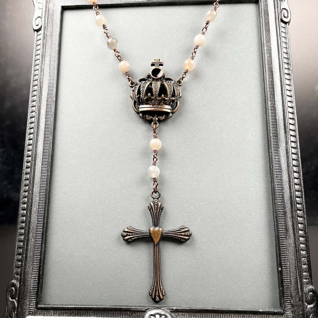 Showing dimensional crown detail on beaded rosary necklace