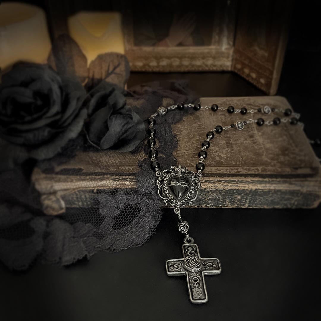 black sacred heart rosary shown on an old book
